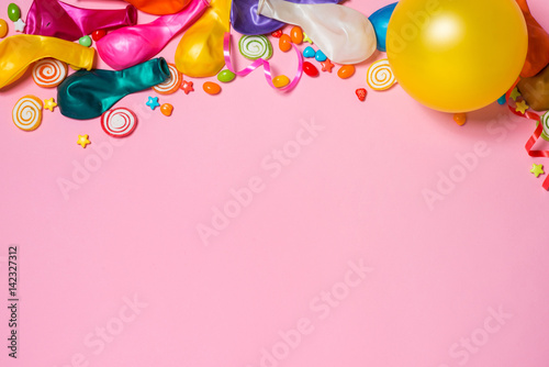 Celebration Flat lay. Candy with colorful party items on pink background.
