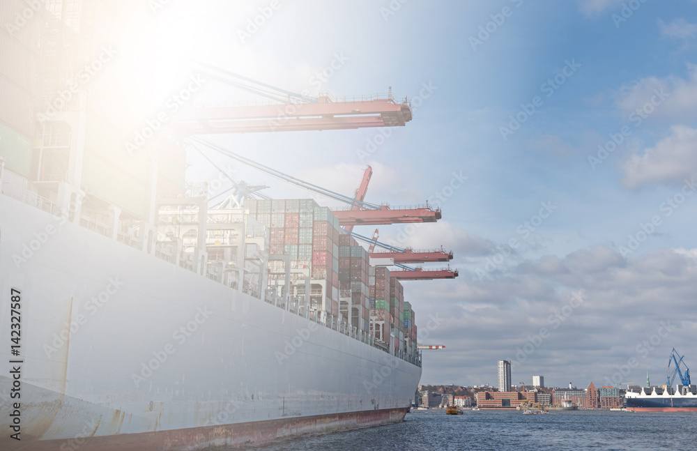 Fototapeta premium industrial harbor with vessels and container ship loading unloading in sunlight.
