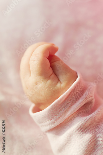 Closeup of Cute Little Baby Hand. Selective Focus. Pink Background.