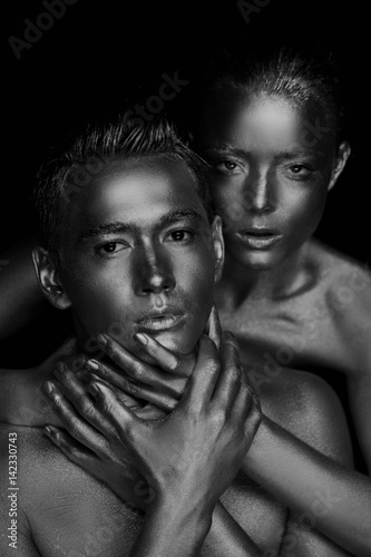 A girl and a boy, covered in gold paint. Large hands on his neck. The lack of freedom.Possessiveness. Black and white
