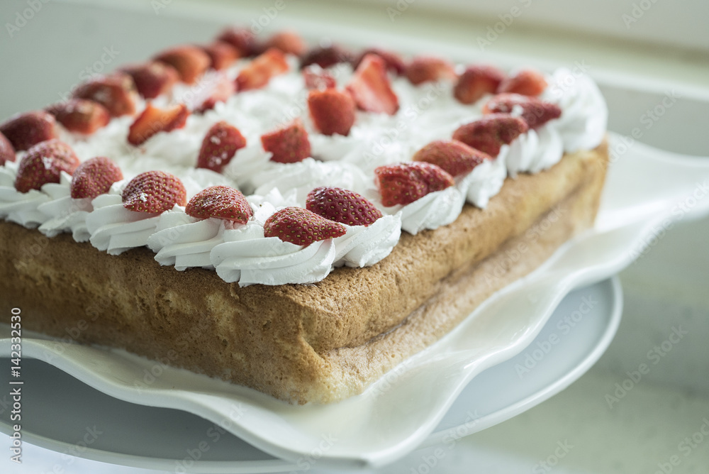 Closeup of Tres Leches cake decorated with strawberry and whipped cream Closeup of Tres Leches cake decorated with strawberry and whipped cream