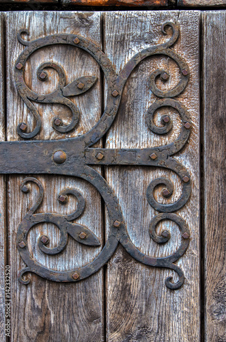 Ornate door.Rusty metal hinge of old wooden door. Isny im Allgau,Gemany