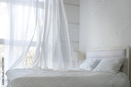 White themed bed sheets and white curtain in the morning, bedroom interior