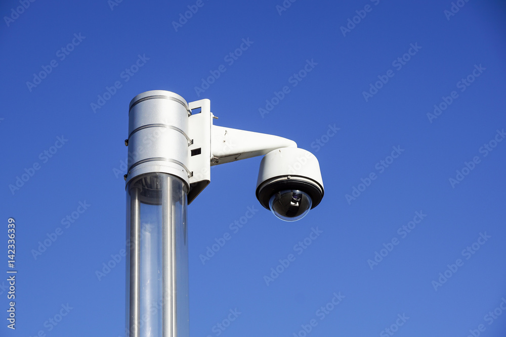 High tech overhead security camera with a blue sky High tech overhead security camera with a blue sky
