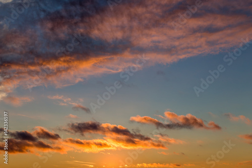 Abstract sky background with fluffy clouds In warm tones, cloudscape pattern, co © DedMityay
