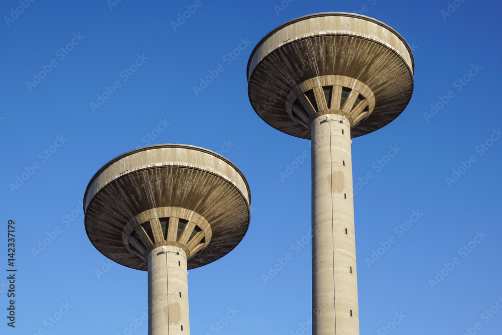 concrete two water towers against blue sky concrete two water towers against blue sky