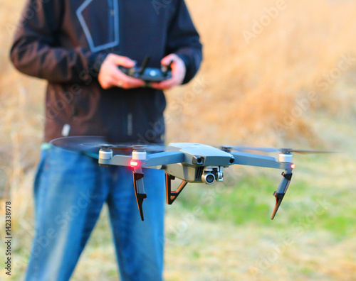 Unidentified man piloting drone quadrocopter with high resolution camera.