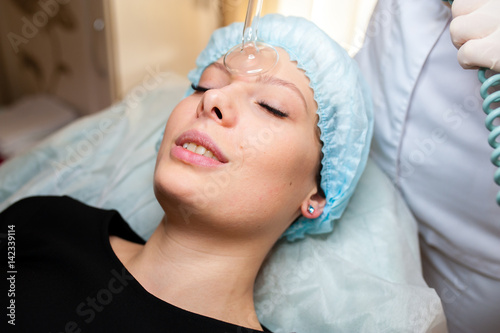 Face Beauty Treatment. Woman Getting Facial Darsonval Therapy Using High Frequency D'Arsonval, Skin Care Device For Anti Spot An photo