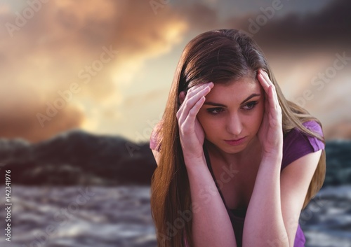 Sad young woman in against csunset and ocean