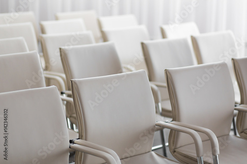 background of row of white seats. Empty chairs in the conference hall