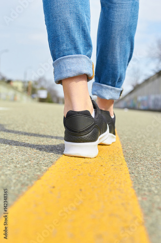 Legs Walking on asphalt road 