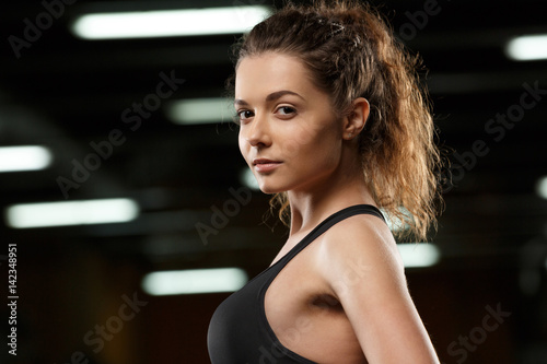 Beautiful young strong sports lady standing and posing in gym © Drobot Dean