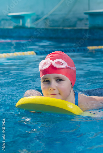 Young girl learning to swim in the pool