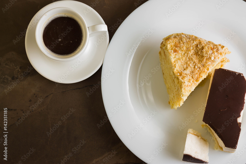 Cake with custard and cake with chocolate on a marble table. Delicious dessert. Cake with custard and cake with chocolate on a marble table. Delicious dessert.