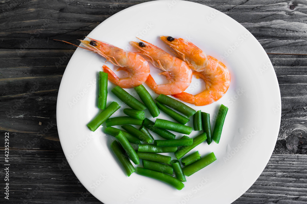 Shrimps with vegetables on a wooden table in rustic style Shrimps with vegetables on a wooden table in rustic style