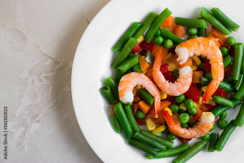Shrimps with vegetables on a wooden table in rustic style Shrimps with vegetables on a wooden table in rustic style