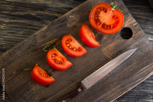 Sliced tomato on a wooden background in rustic style