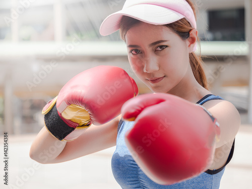 Selected focus of young beautiful women wear a red Thai boxing gloves for outdoor © rachaphak