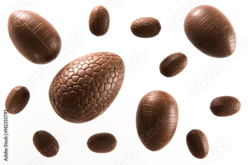 Foto High angle view of a variety of unwrapped Easter chocolate eggs on a white backg