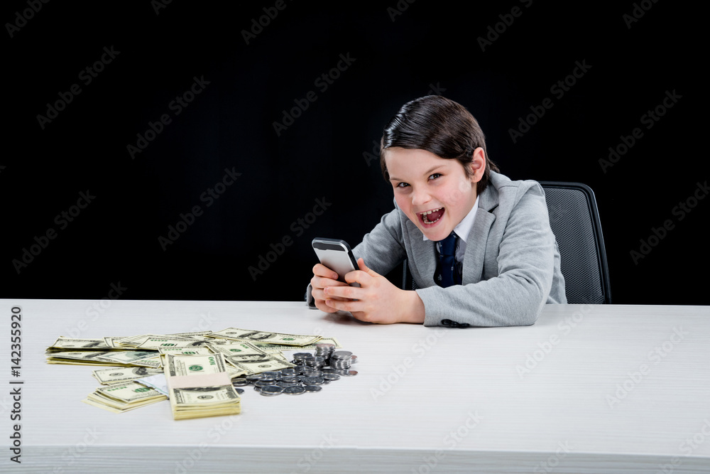 portrait of cunning boy playing businessman and using smartphone on black portrait of cunning boy playing businessman and using smartphone on black