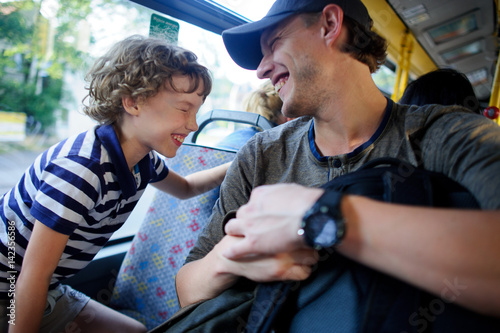 The young man goes by the bus together with the son.