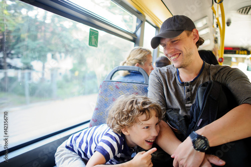 The young man goes by the bus together with the son.