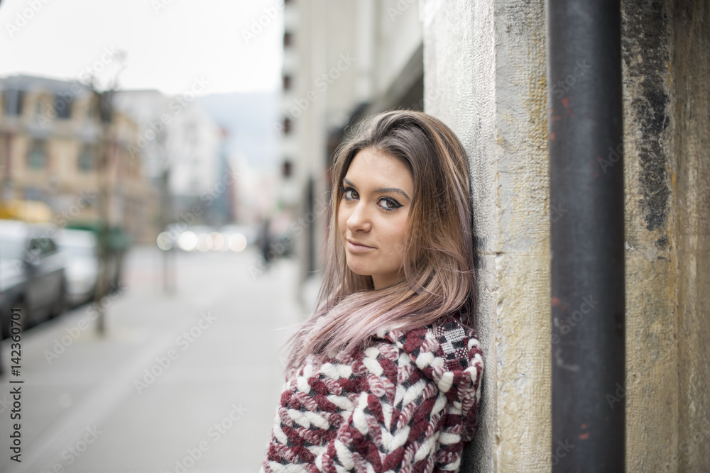 Portrait of beautiful young woman in the street looking at camera.