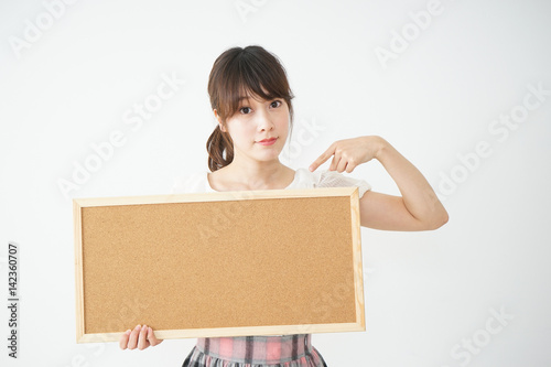コルクボードを持つ若い女性