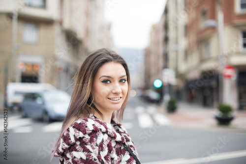 Portrait of beautiful smiling young woman in the street.