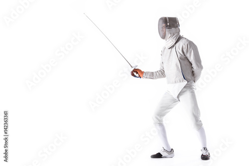 Side view of man wearing fencing suit practicing with sword