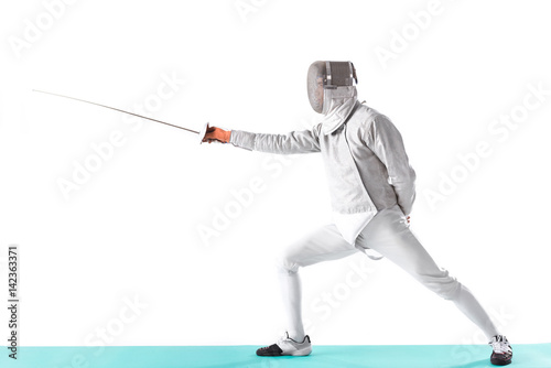 side view of fencer in uniform trainign with rapier in hand on white