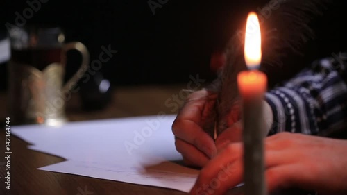 Close-up of a hand as it writes a letter on a paper.