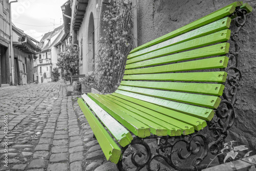 Green bench on an old city
