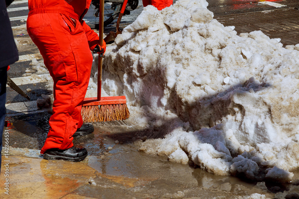 Workers sweep snow from road in winter. Cleaning road from snow storm