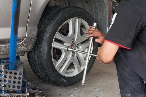 Unidentified worker change tire, movement action. © ZhouEka