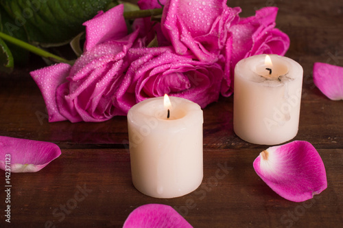 Pink roses and candles on a bright background