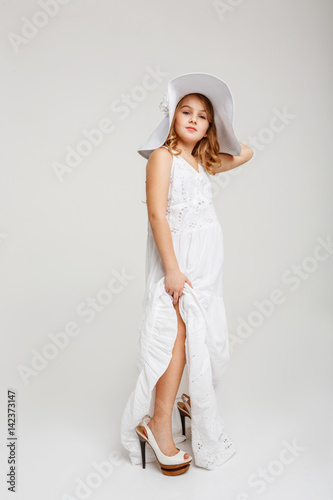 Billede på lærred Girl in white hat, white maxi dress, white heels shoes.
