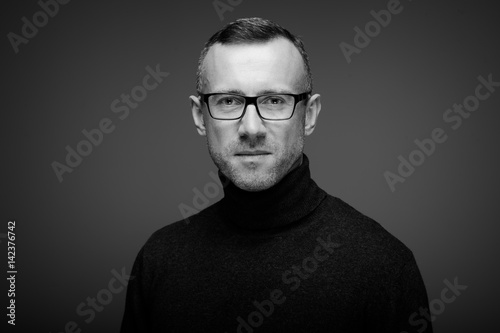 portret mężczyzny w studio na ciemnym tle w okularach photo