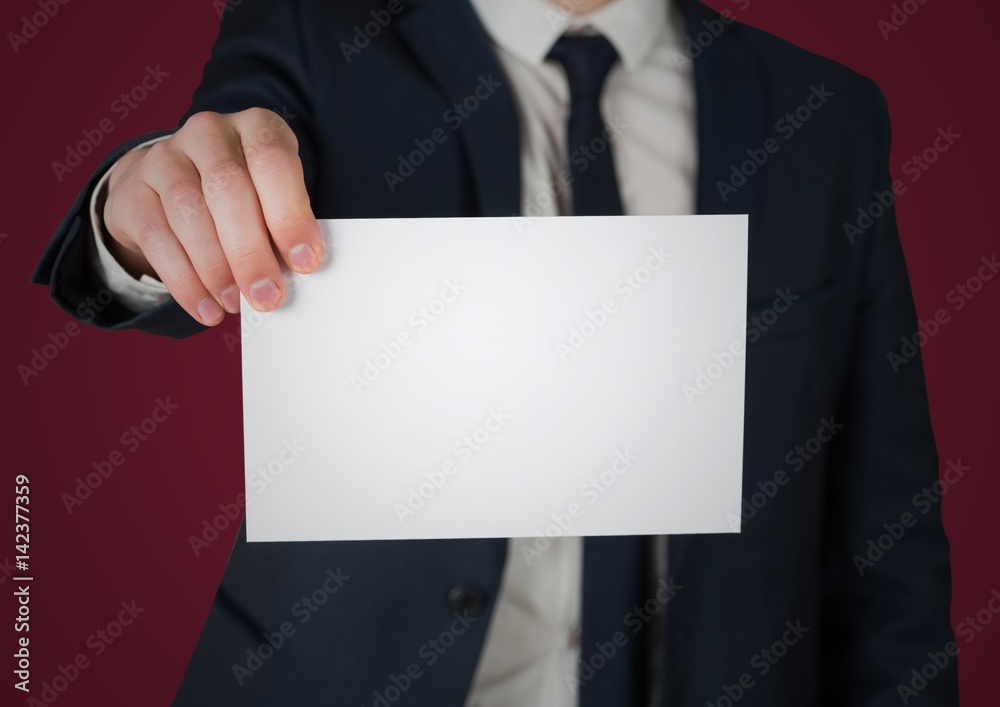 Business man holding out blank card against maroon background Business man holding out blank card against maroon background