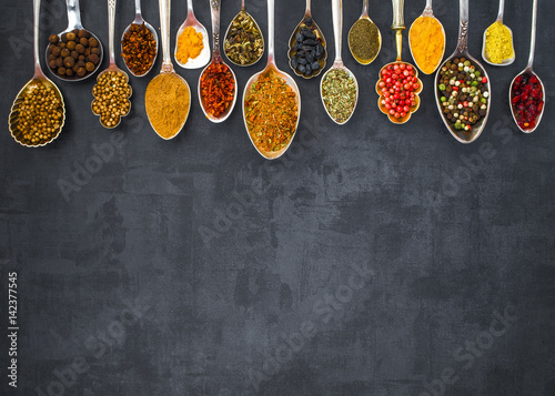 Fototapeta Naklejka Na Ścianę i Meble -  Various spices spoons on stone table. Top view .