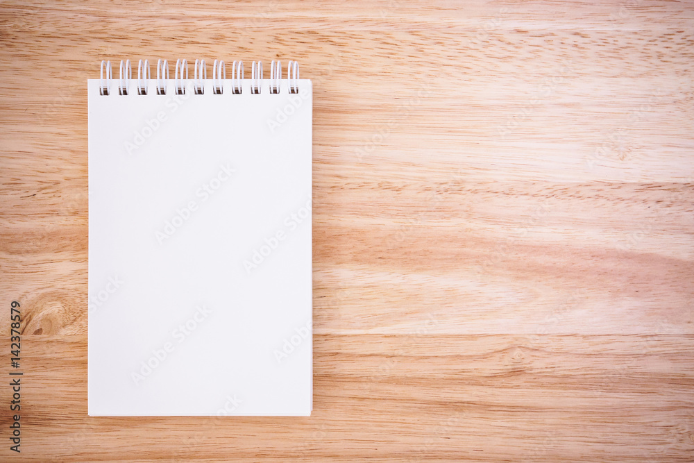 Notepad on the wooden desk table Notepad on the wooden desk table