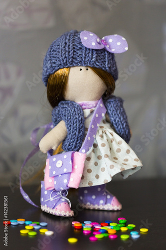 Текстильная кукла в голубом платье в горошек, в вязанных синих шапке и жилете, в кедах из фиолетового и розового фетра, с сумочкой из фетра 