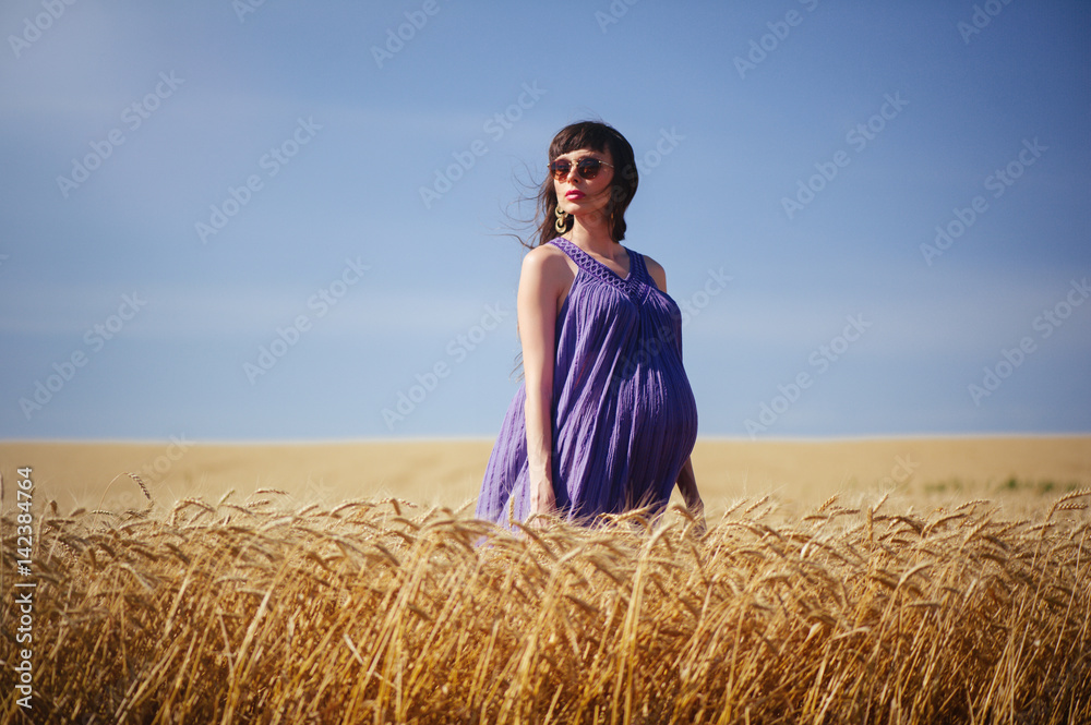 Naklejka premium pregnant woman in wheat field
