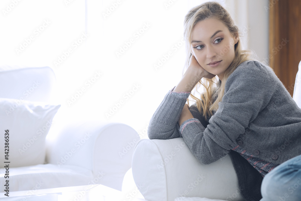 Young beautiful woman sitting on couch at her room Young beautiful woman sitting on couch at her room