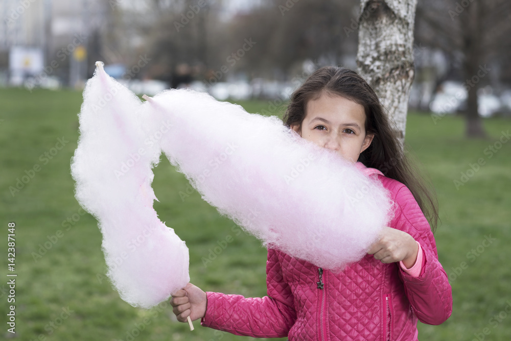 Horizontal picture of cute preteen girl eating cotton candy Horizontal picture of cute preteen girl eating cotton candy