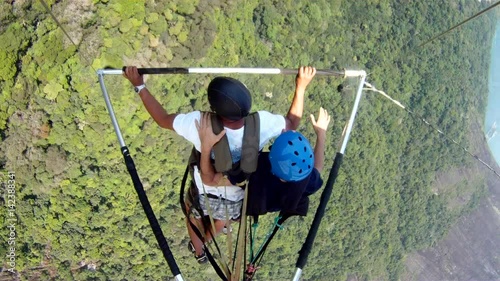 Camera attached in hang glider. Camera looking from above over people flying over scenic view. Flight sport photo