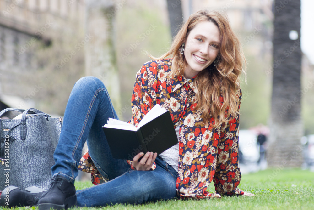 Obraz premium girl reading book at park