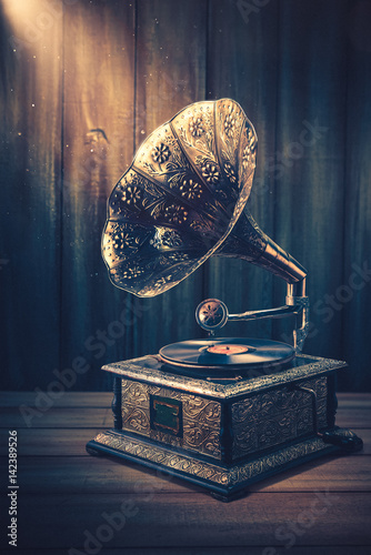 Old Gramophone with dramatic lighting on a wooden background