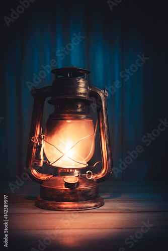kerosene lamp on a wooden background with dramatic lighting
