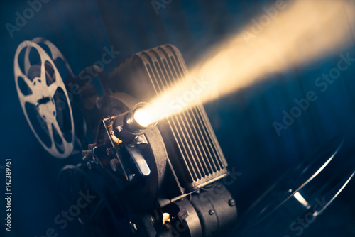 movie projector on a wooden background with dramatic lighting and selective focus
